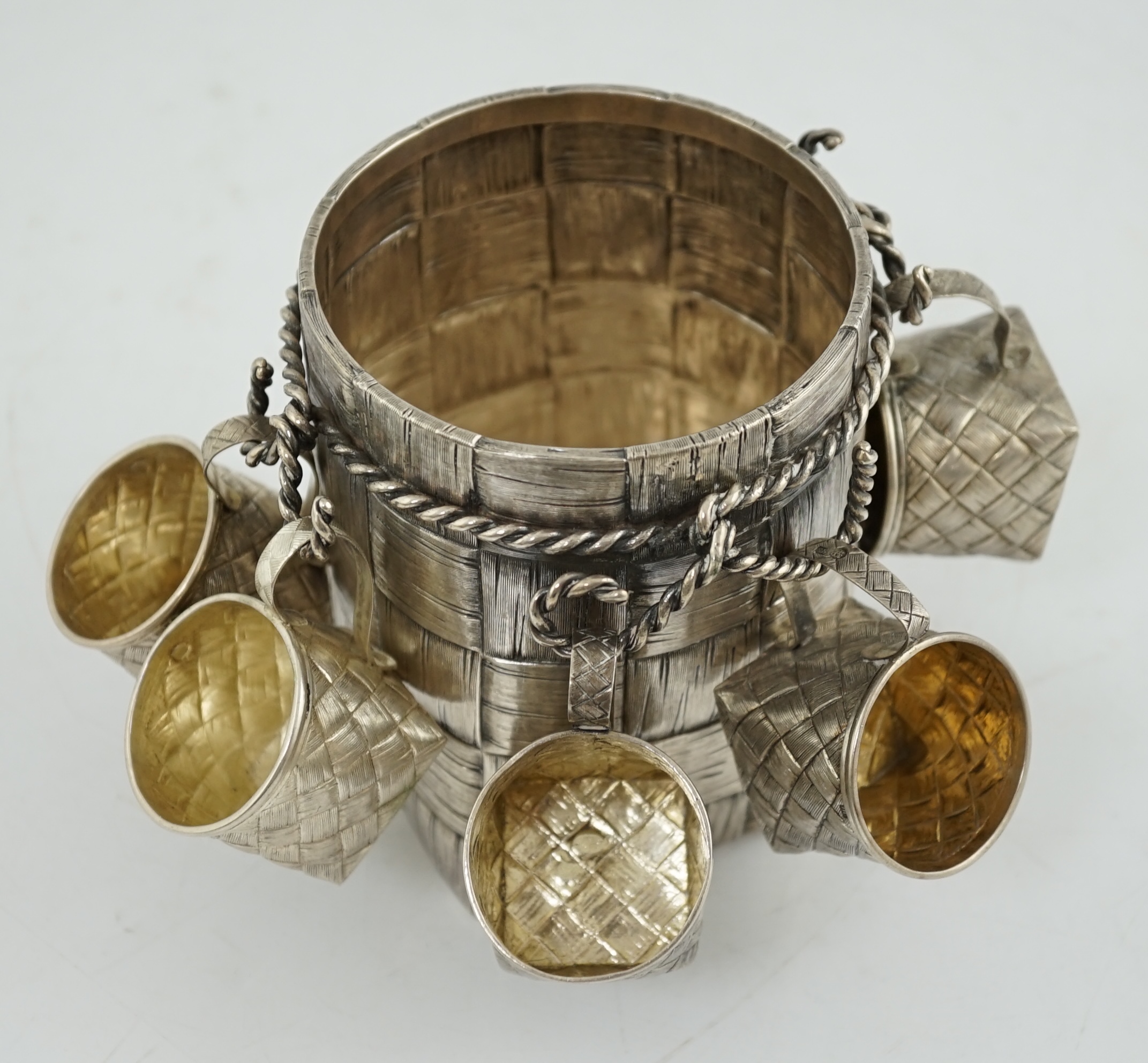 A late 19th century Russian 84 zolotnik silver bottle holder, with basket weave decoration, together with five similar tots